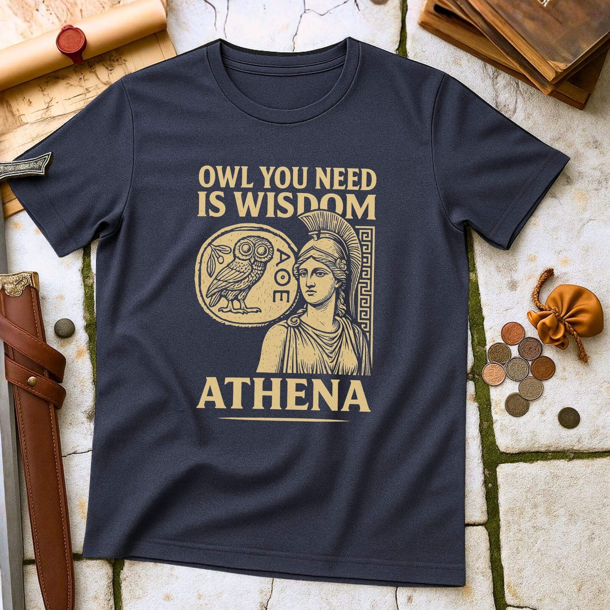 Heather Navy blue t-shirt with gold graphic and text on a textured surface with books and coins.