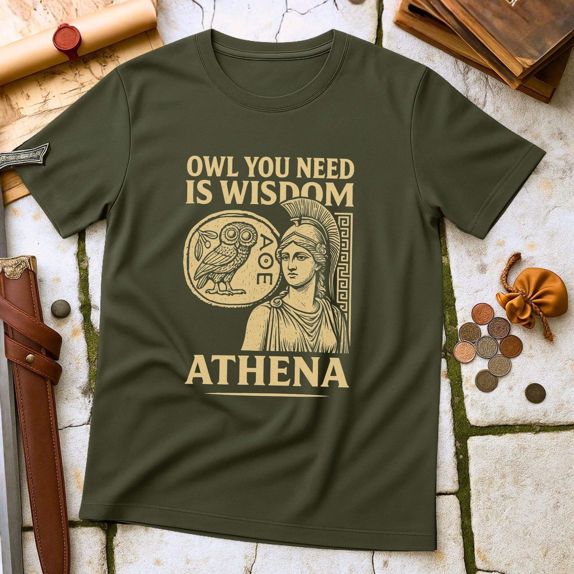 Military Green t-shirt with Athena graphic and text on a stone surface with coins and scrolls.