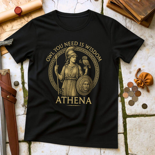 Black t-shirt with Athena graphic and text 'OWL YOU NEED IS WISDOM ATHENA' on a stone surface with classical items.