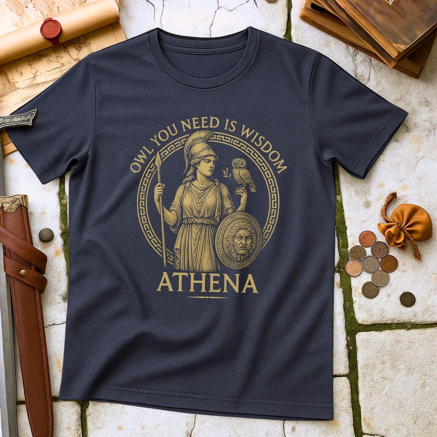Heather Navy blue t-shirt with Athena graphic and text on a stone surface with classical items.