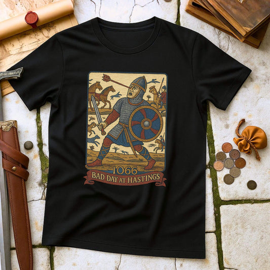 Black t-shirt with a graphic of a knight and text '1066 Bad Day at Hastings' on a stone surface.