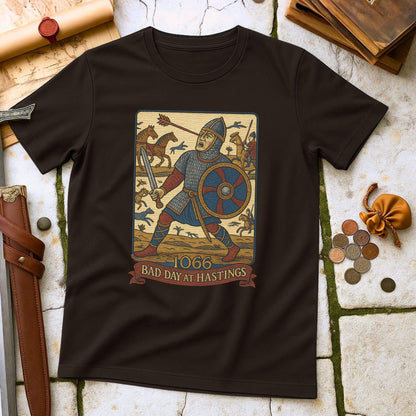 Black t-shirt with a graphic design of a knight and text '1066 Bad Day at Hastings' on a stone surface.