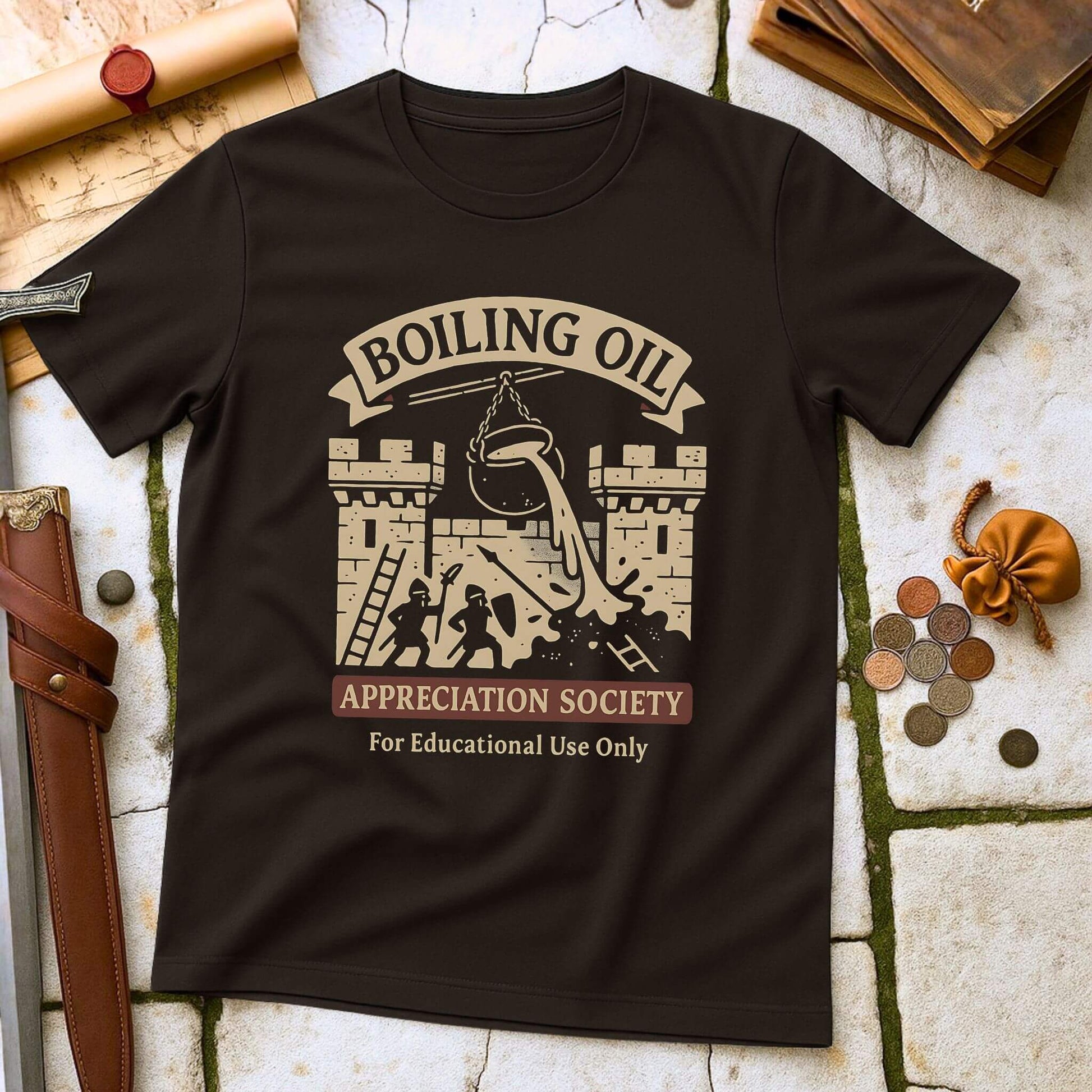 Dark_Chocolate t-shirt with 'Boiling Oil Appreciation Society' graphic on a stone surface with coins and books.