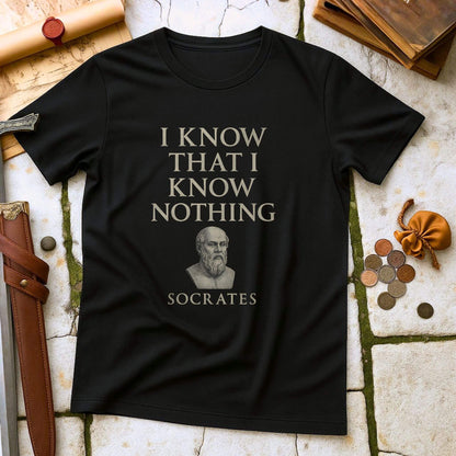 Black t-shirt with 'I Know That I Know Nothing' Socrates quote on a stone surface with historical items.