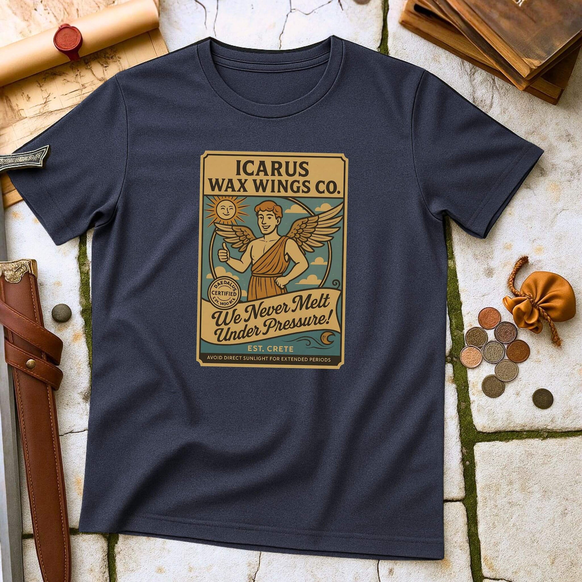 Heather Navy blue t-shirt with 'Icarus Wax Wings Co.' graphic on a textured surface with vintage items.